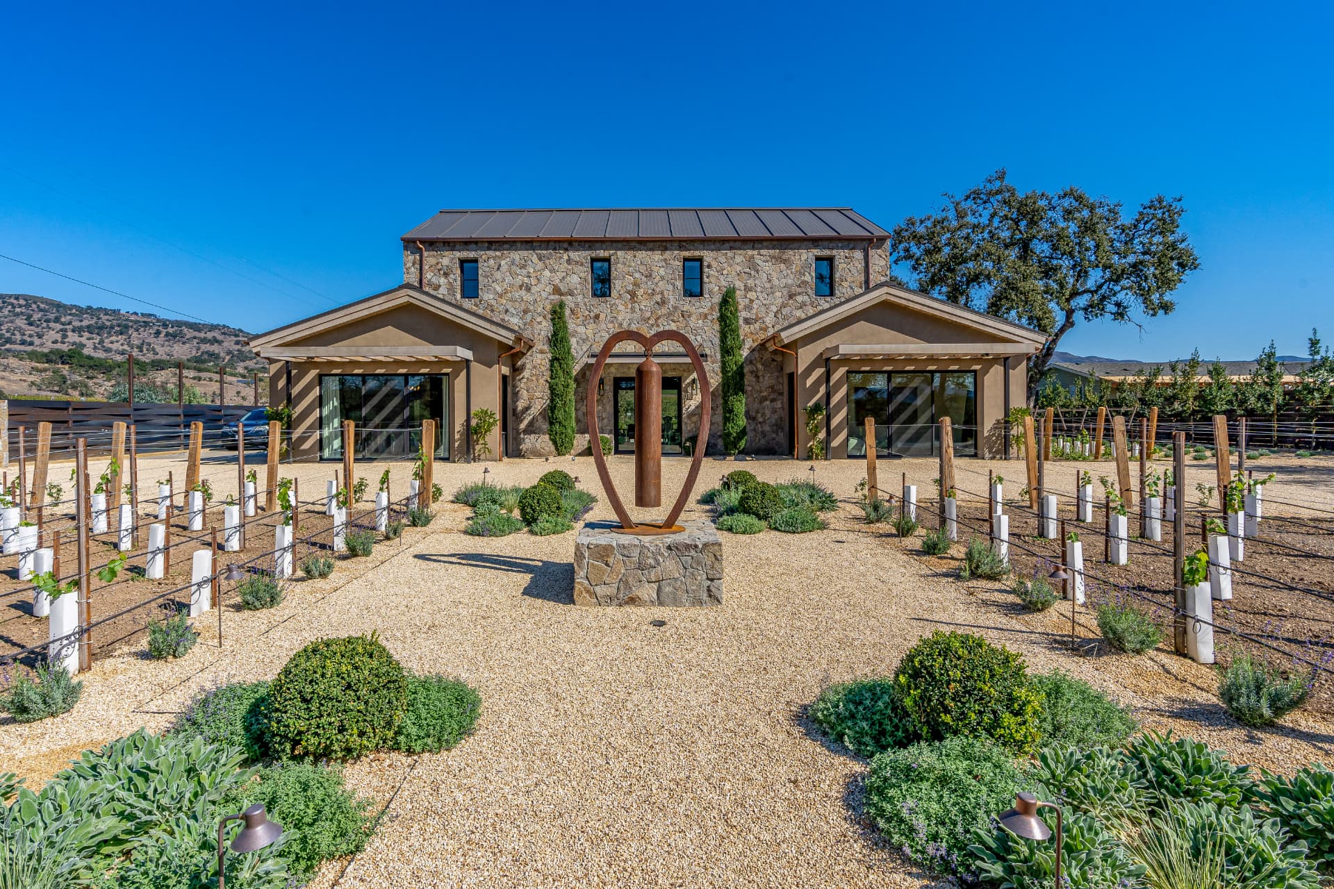 Stone and stucco wine country residence with courtyard and young vines