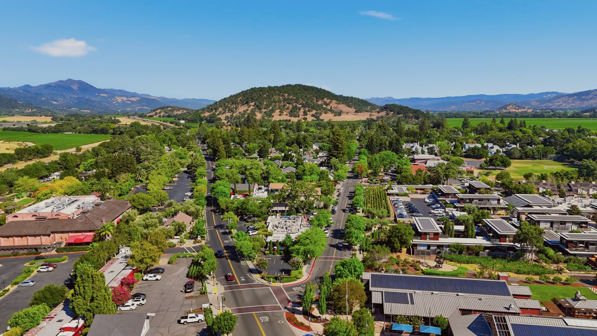 Aerial view of downtown Yountville, CA with tree-lined streets, Washington Street and valley hills beyond